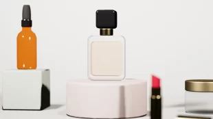 Foto de produto no Estúdio de Produto do simulador do Canal da Foto: frasco de perfume sobre fundo claro, com conta-gotas, batom e pote de creme ao redor