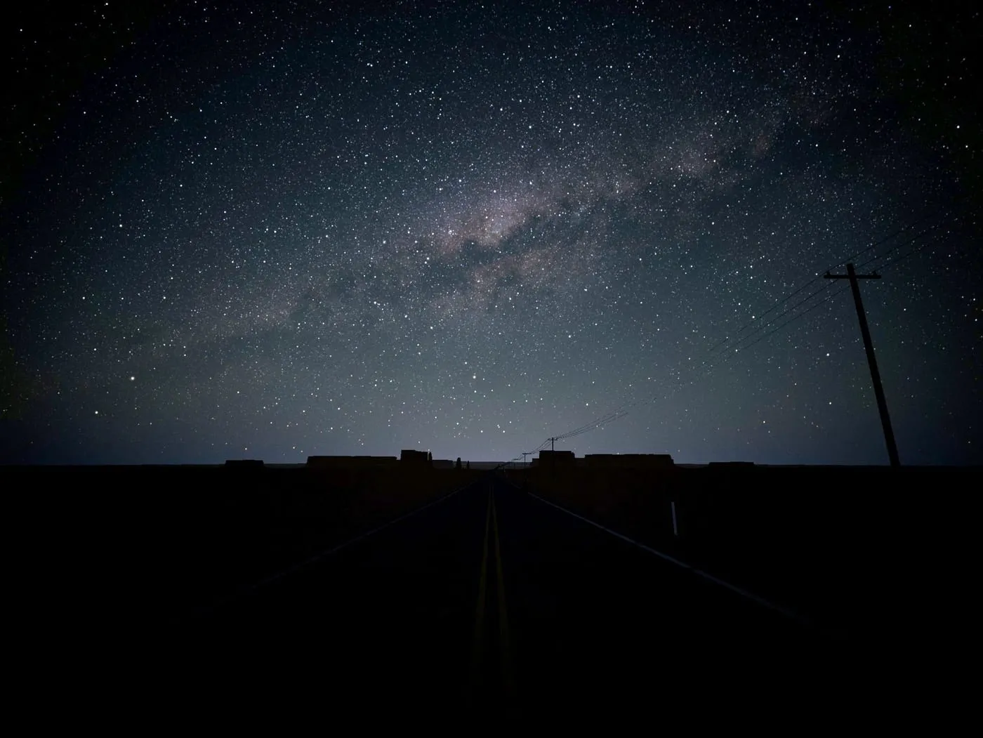 O núcleo da Via Láctea descendo no oeste-sudoeste sobre uma estrada no deserto, numa noite de setembro
